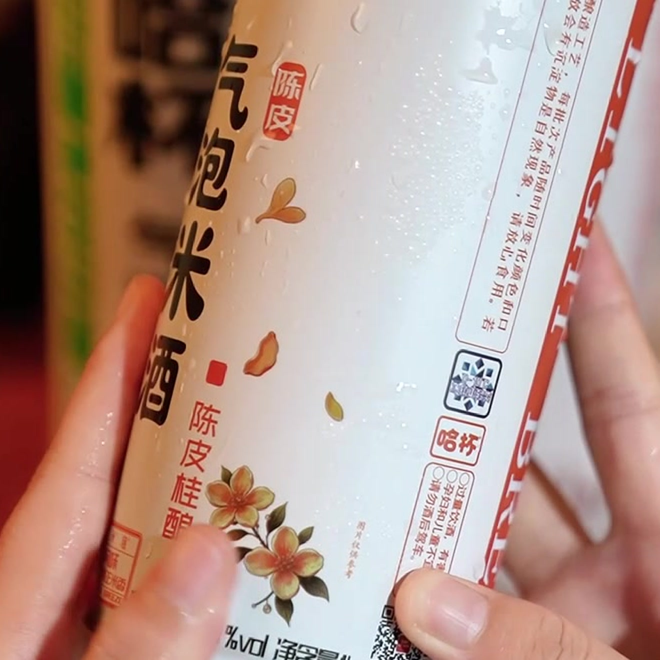 陈皮味罐体特写：水珠、桂花/陈皮插画、「哈杯」标识与净含量 1L 字样清晰可见。