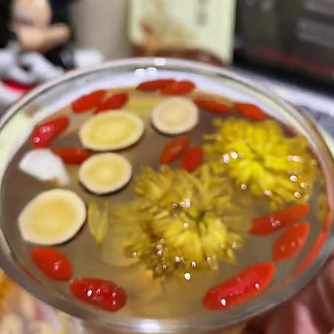 皇菊枸杞甘草在茶汤中漂浮，汤色清亮