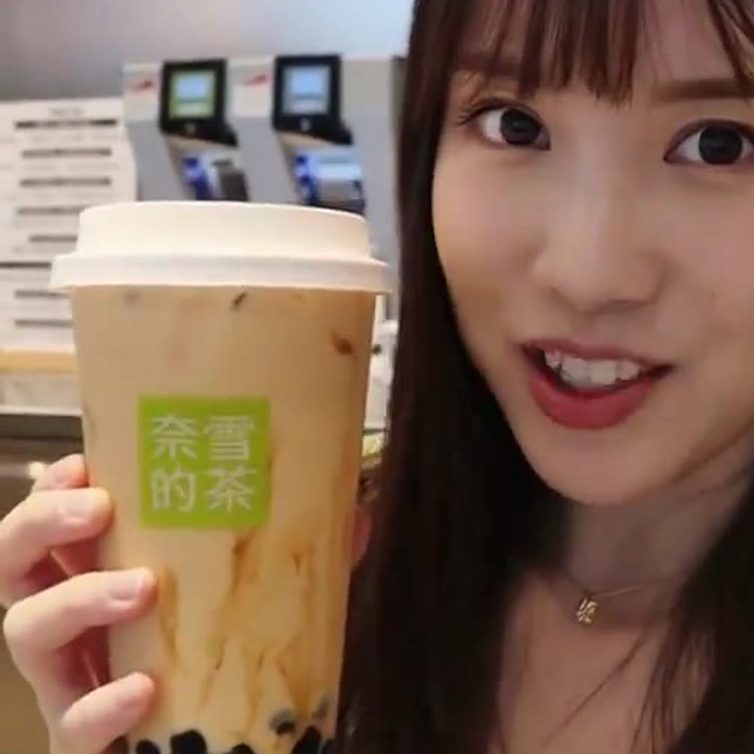 举杯口播半身:女生门店内手持奶茶对镜讲解